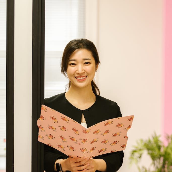 Woman in Black Dress Holding Floral Folder